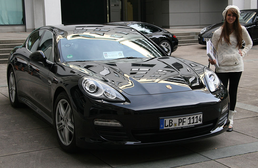 lady standing near porsche