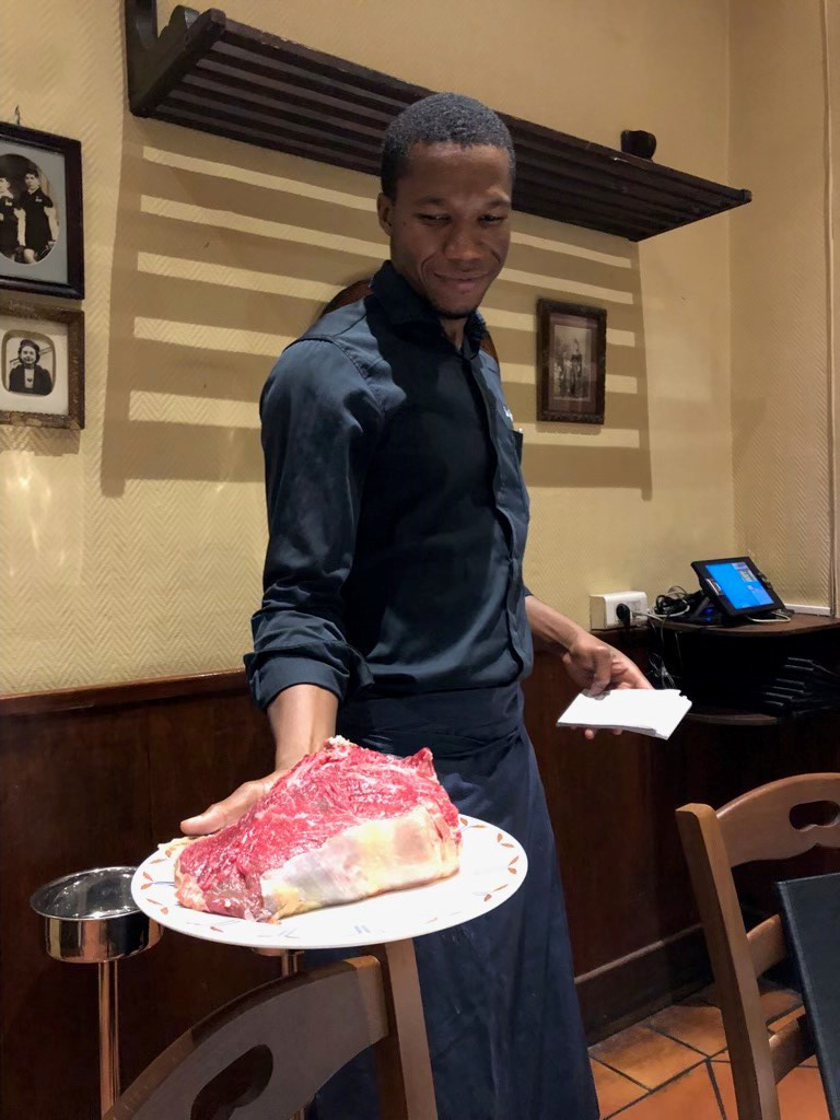 waiter holding steak