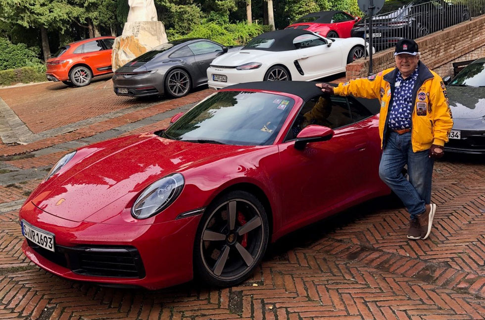 Peter beside a red Porsche