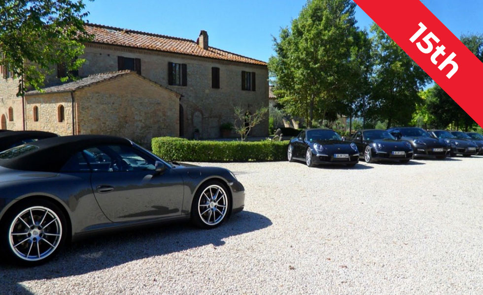 porsches in front of tuscany estate with 15th trip banner