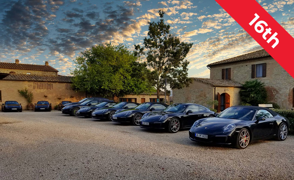 porsches in front of private tuscany estate with 16th trip banner